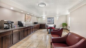 Eine Hotelküche mit einer langen Theke, einer Kaffeemaschine und einem Essbereich mit Tisch und Stühlen.