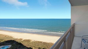 Un balcón con vista a la playa y al océano.