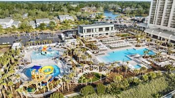 Un complexe hôtelier doté de plusieurs piscines, d’un parc aquatique et d’un grand bâtiment avec des balcons.