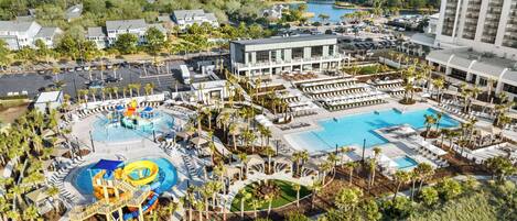 A resort with multiple swimming pools, a water park, and a large building with balconies.