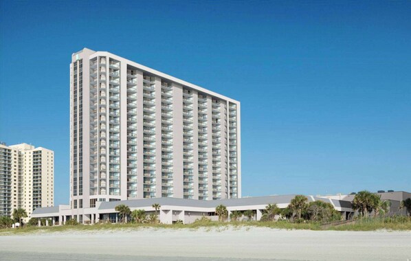 A high-rise hotel with multiple balconies, located near a beach with a clear sky. - Embassy Suites by Hilton Myrtle Beach Oceanfront Resort (Myrtle Beach)