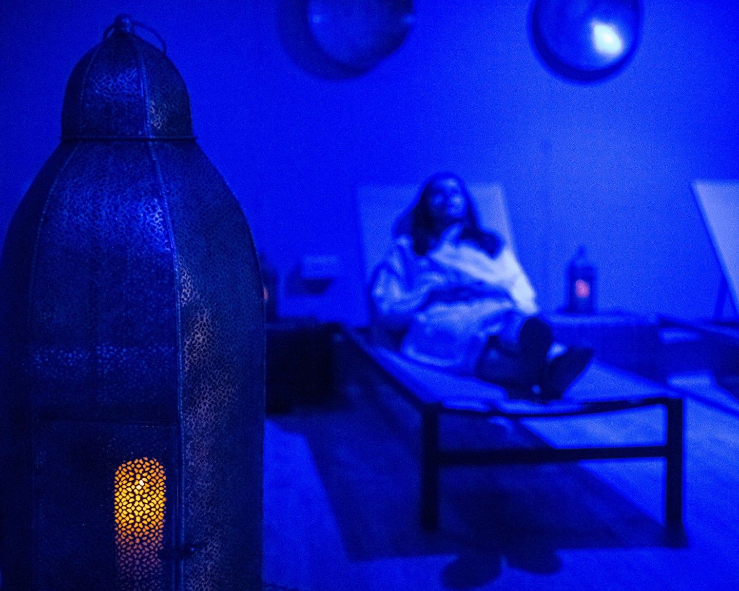 A room with a bed, a bedside table, and a lamp.