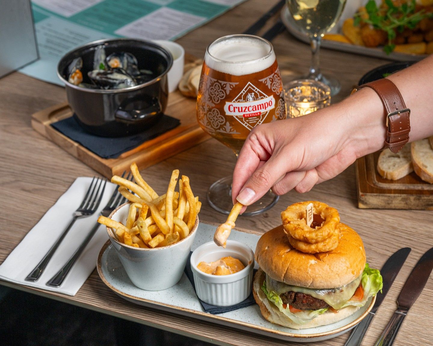 A meal with a burger, fries, and a glass of beer on a tray.