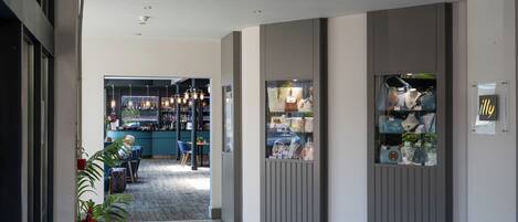 A hallway with a bar area, a display of handbags, and a fire extinguisher.