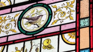 A stained glass window with a bird and fruit motifs.