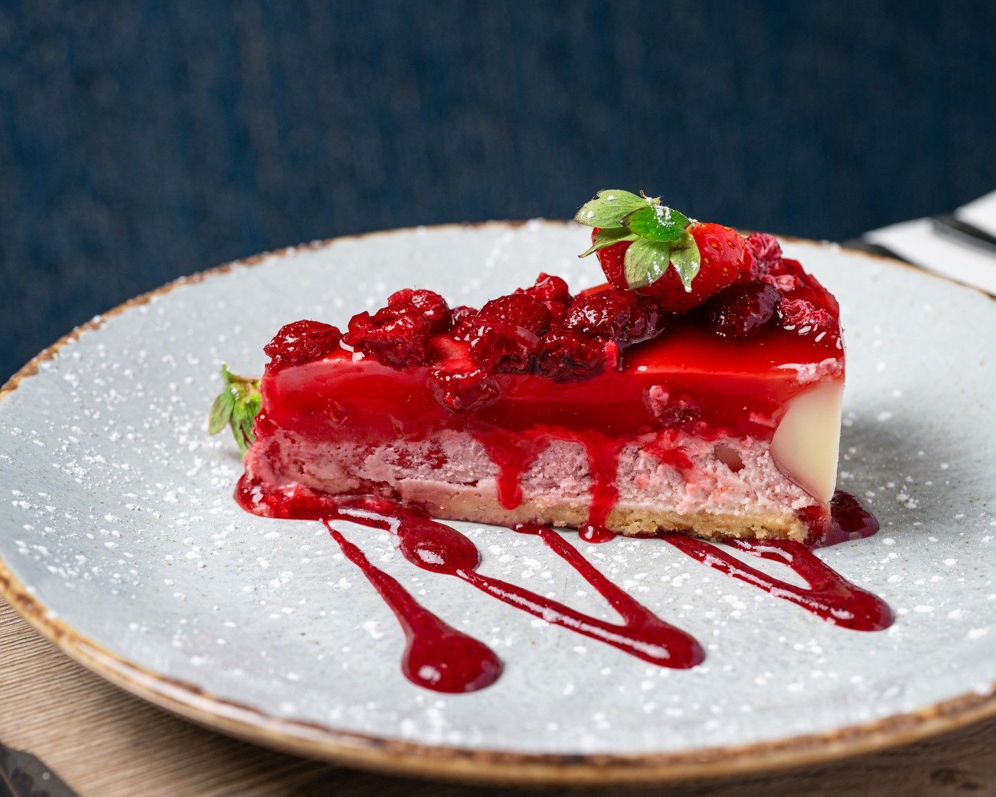 A slice of dessert with a berry topping on a white plate.