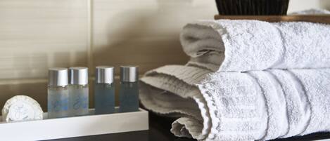 A bathroom counter with toiletries, a towel, and a hairbrush.