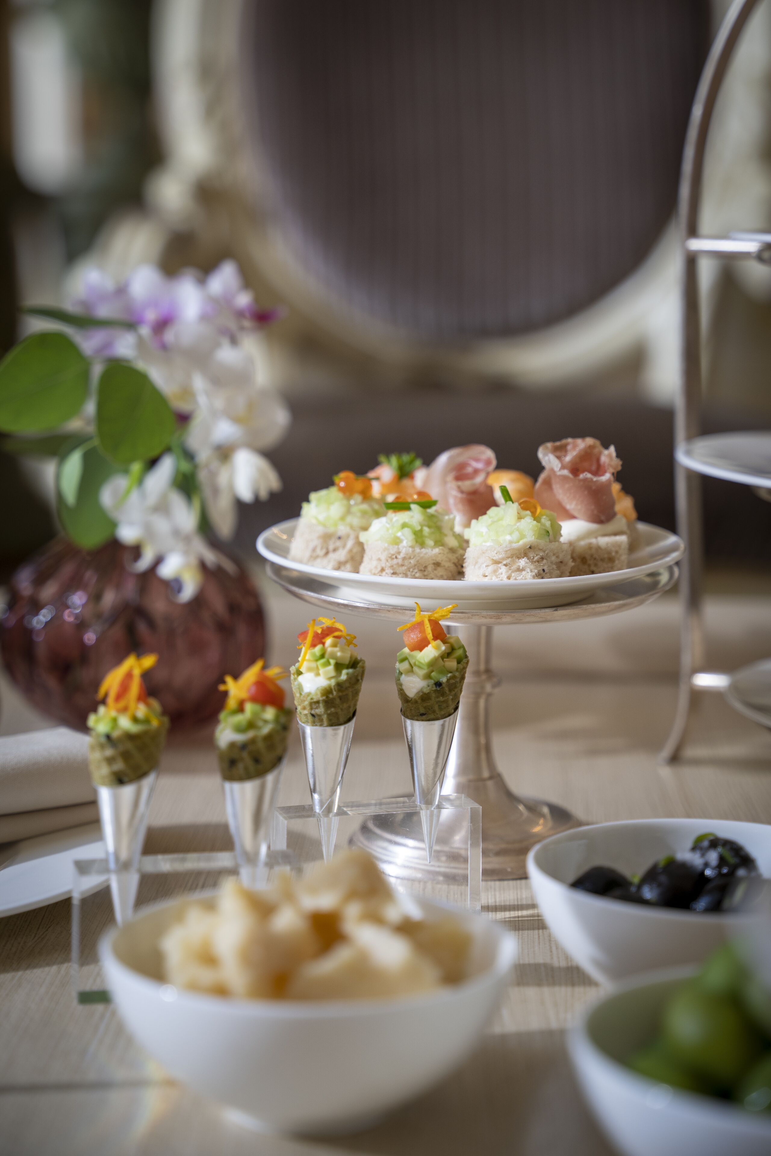 Una mesa de postres con diferentes alimentos y un jarrón de flores.