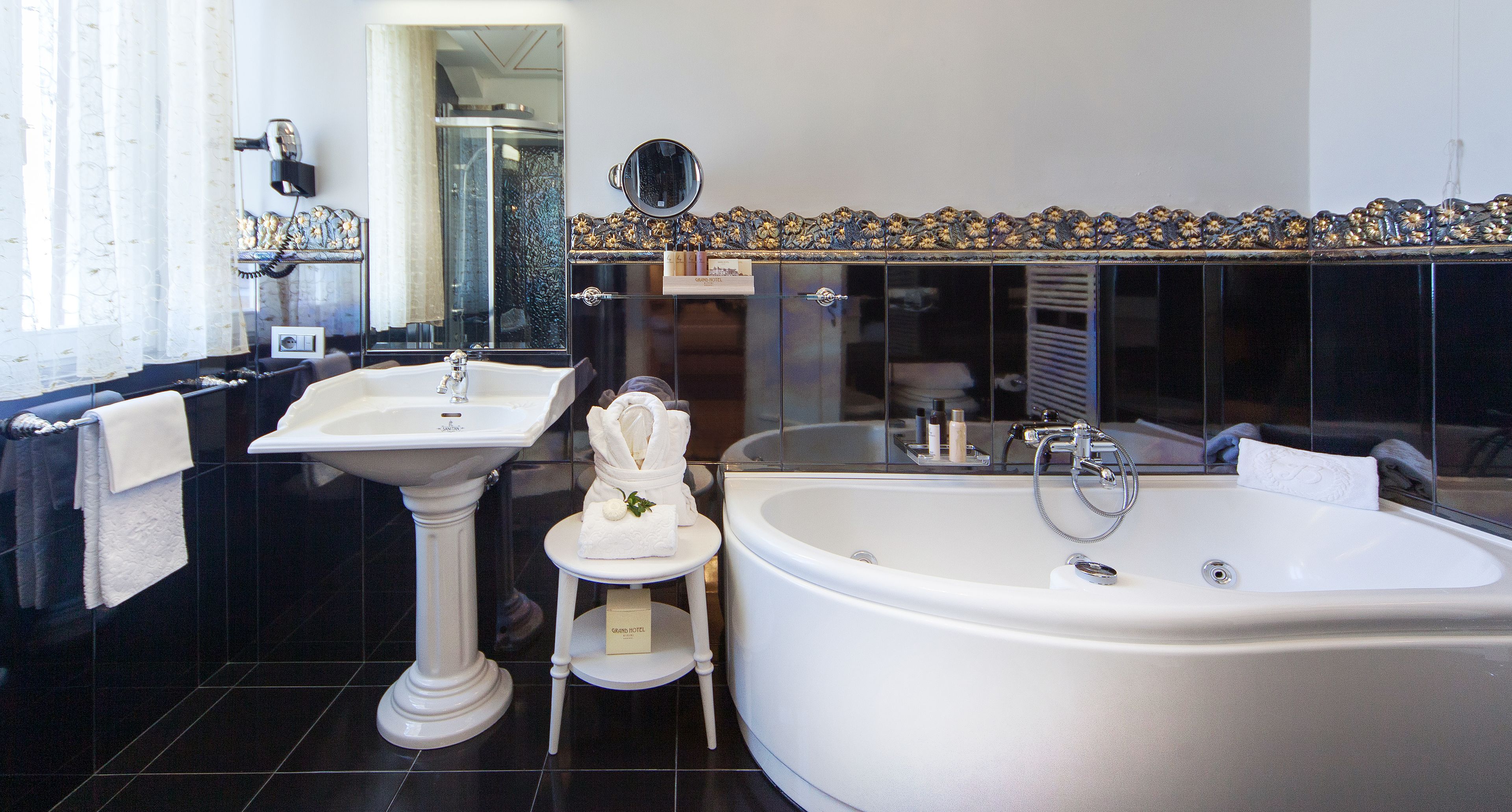 Ein Badezimmer mit einem Standwaschbecken, einer Badewanne und einem Schminkspiegel.