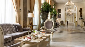 A luxurious lobby with a grand chandelier, elegant furniture, and a central table set for a tea service. - Grand Hotel Rimini (Rimini)