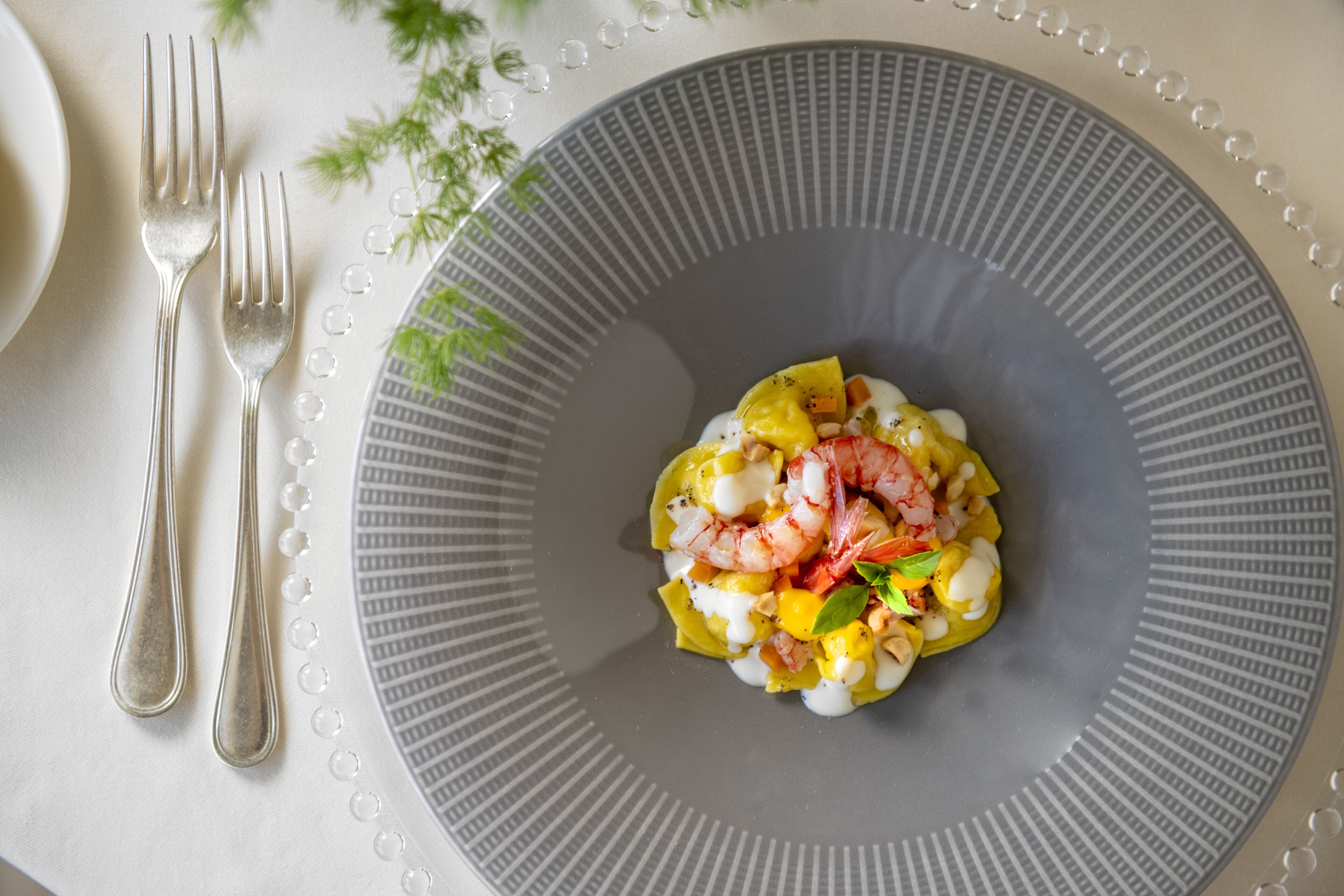 A plate of food with shrimp and vegetables on a gray plate.