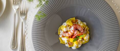 A plate of food with shrimp and vegetables on a gray plate.