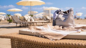 A beach setting with lounge chairs and umbrellas. - Grand Hotel Rimini (Rimini)