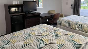 A hotel room with two beds, a desk, a television, and a wardrobe.