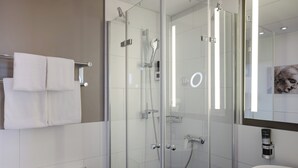 A modern bathroom with a glass-enclosed shower, a white sink, and a towel rack. - Leonardo Hotel Heidelberg City Center (Heidelberg)