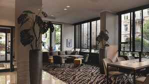 A modern hotel lobby with a seating area, large windows, and a patterned carpet. - Leonardo Hotel Heidelberg City Center (Heidelberg)