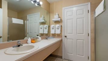 A bathroom with two sinks, a mirror, and a door.