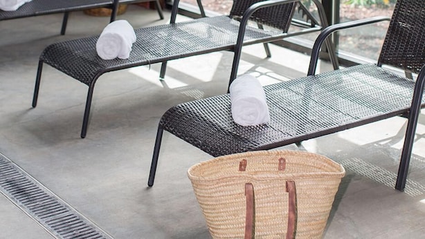 A sunlit indoor seating area with metal chairs and a woven basket. - Red Lion Hotel Rogue Regency Medford Airport (Medford)