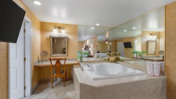 A bathroom with a large mirror, a bathtub, and a vanity with a sink.
