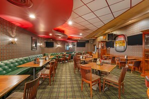 A restaurant interior with booths, tables, and a patterned carpet. - Red Lion Hotel Rogue Regency Medford Airport (Medford)