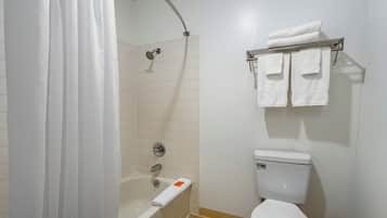 Een badkamer met een bad, douche, toilet en handdoekrek.