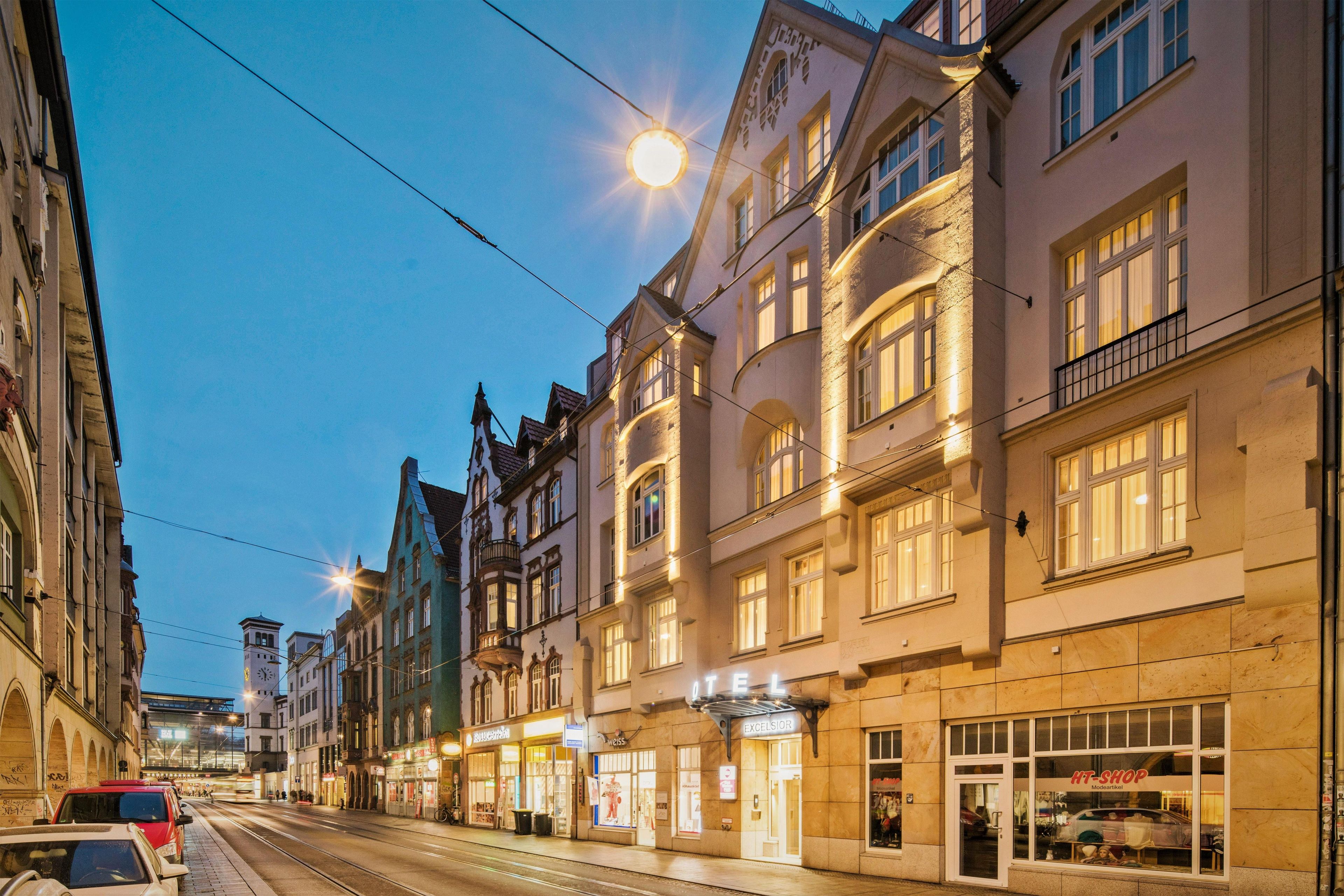 A street view of a building with a sign that reads 'HOTEL EXCELSIOR.'
