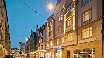 Straatbeeld van een gebouw met een bord waarop 'HOTEL EXCELSIOR' staat.