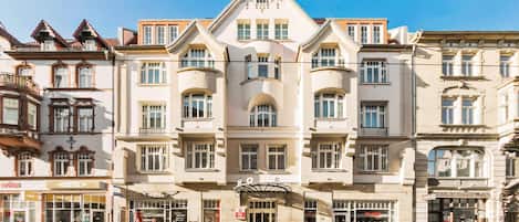 A multi-story hotel with a classic architectural design, featuring a central entrance and multiple windows on each floor.