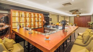 A bar area with a long wooden counter, multiple seating options, and a well-stocked liquor cabinet. - Best Western Plus Hotel Excelsior (Erfurt)