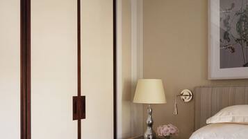 A hotel room with a bed, a nightstand, a lamp, a framed artwork, and a sliding door.