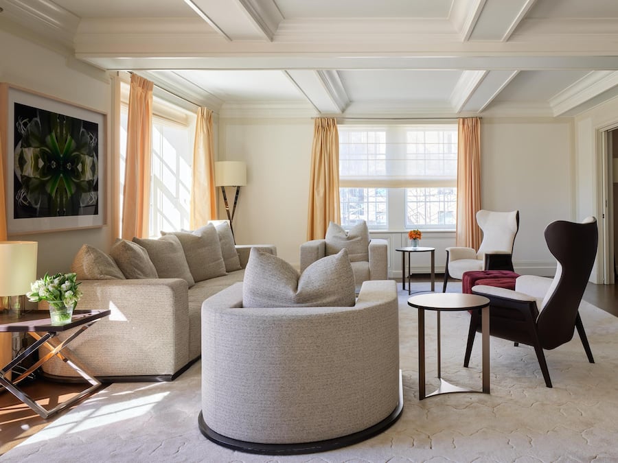 A modern living room with a round sofa, a coffee table, and a bookshelf.