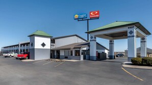 Comfort Inn og EconoLodge med en tankstation, parkeringsplads og en bygning med grønt tag.
