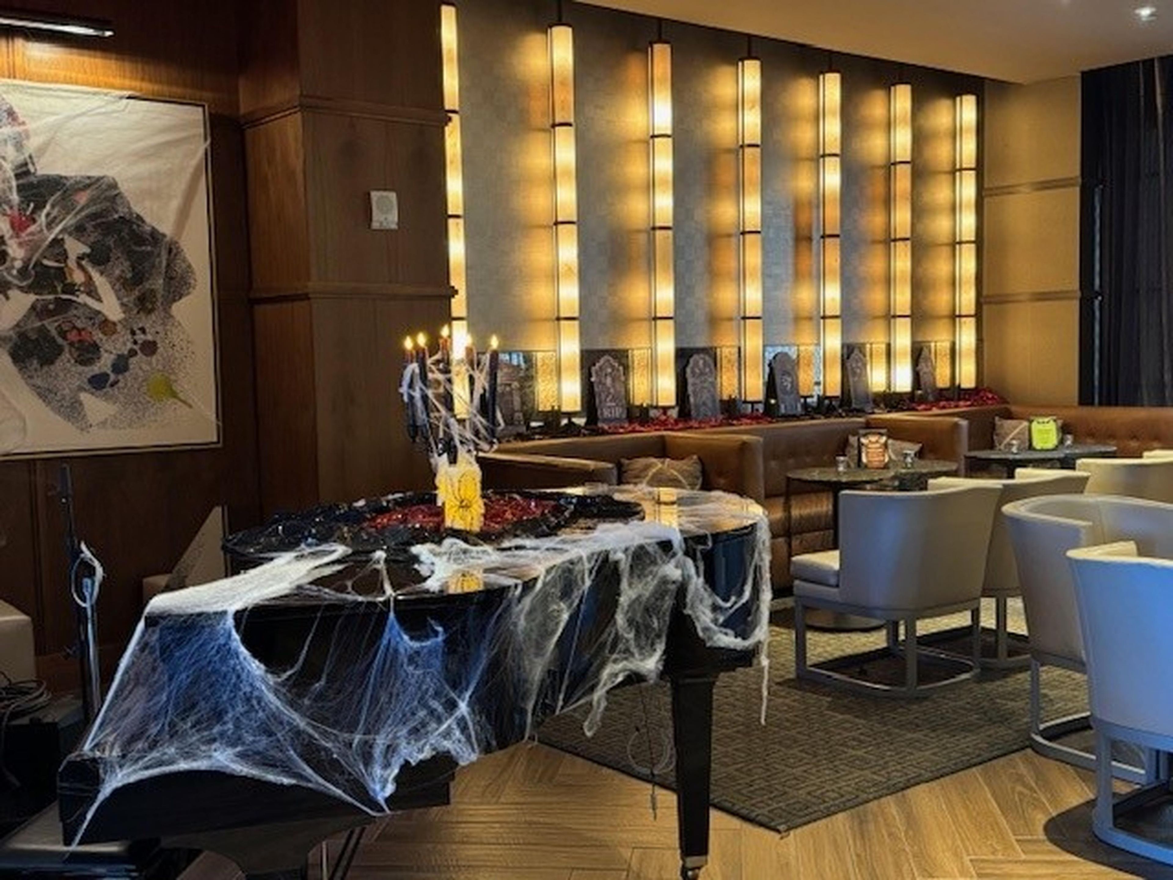 A hotel lobby with a bar area, seating arrangements, and a decorative centerpiece.