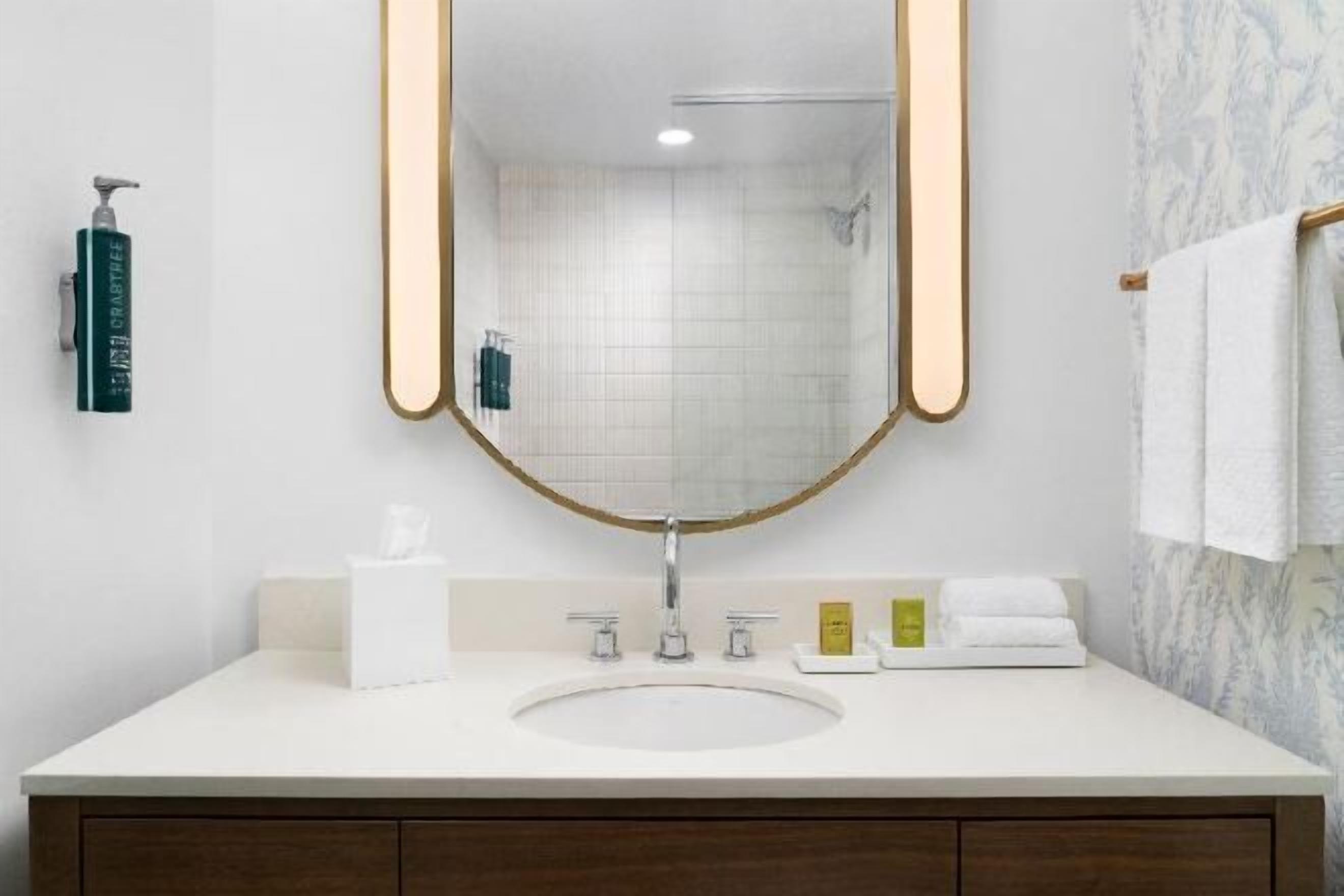 Badkamer | Een bad/douchecombinatie, designer toiletartikelen, een haardroger