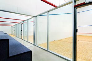A squash court with glass walls and a wooden floor. - Hilton New Orleans Riverside (New Orleans)