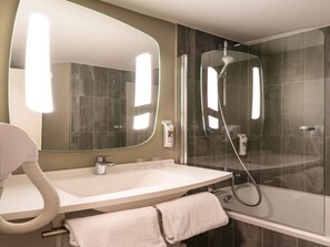 A modern bathroom with a large mirror, a sink, a shower, and a glass-enclosed shower area. - ibis Paris Alésia Montparnasse 14ème (Paris)