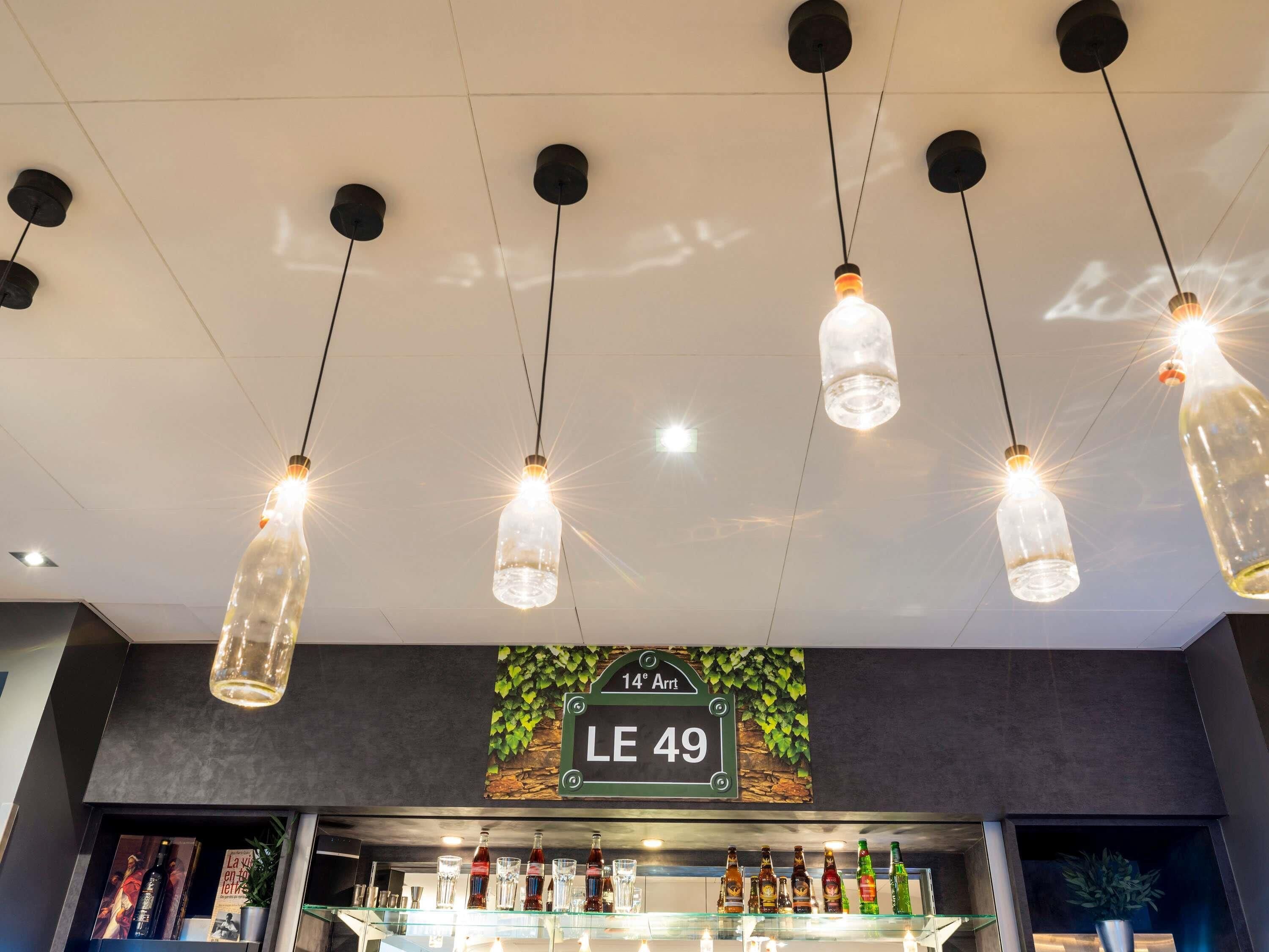 Una zona de bar con varias lámparas colgantes y un letrero que indica la ubicación como "14th Arrt LE 49".