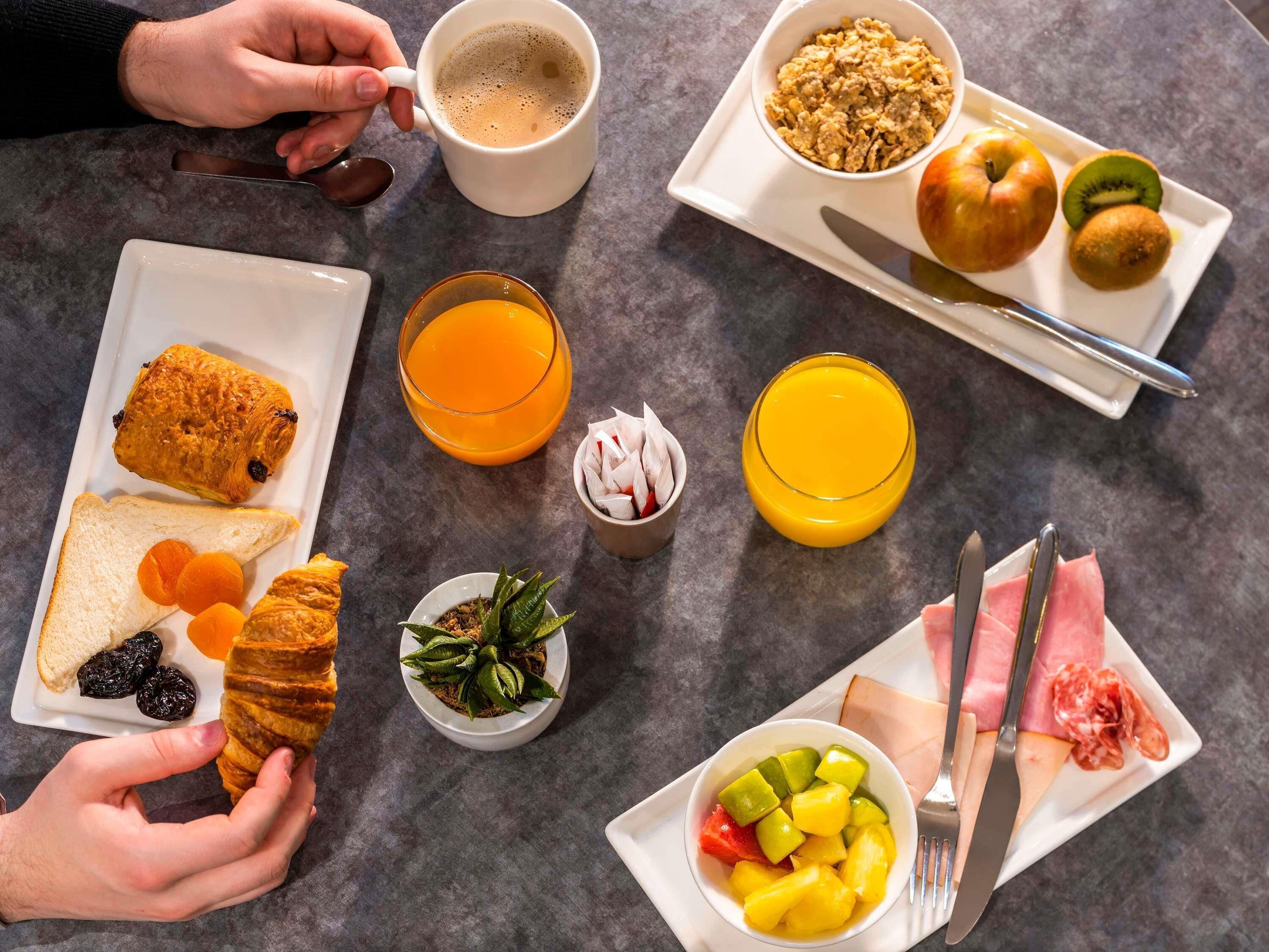 Una mesa con diversos alimentos y bebidas para el desayuno.