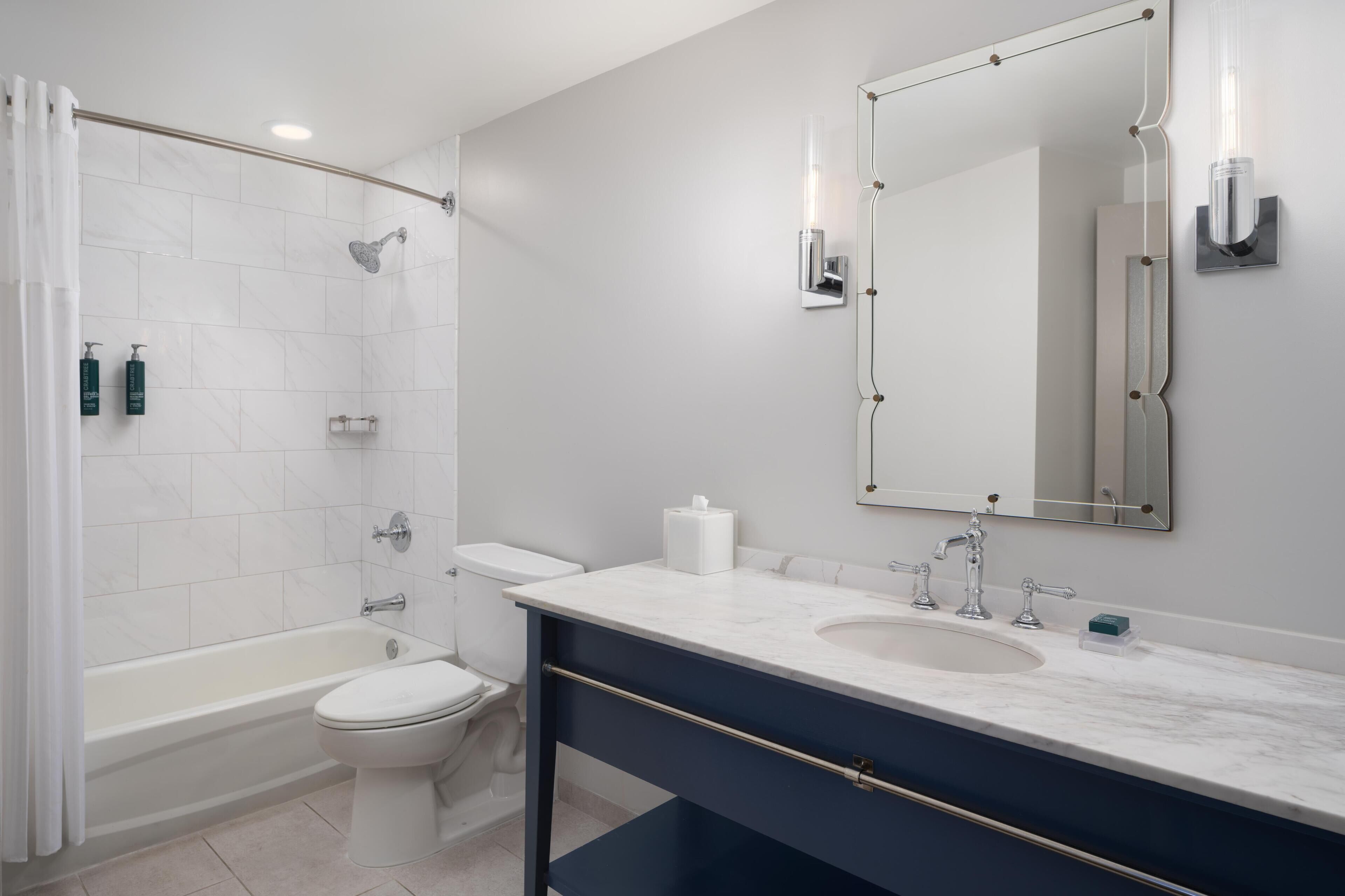Une salle de bain moderne équipée d’une baignoire, de toilettes et d’un lavabo.