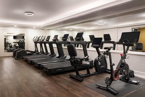A gym with multiple treadmills and an elliptical machine. - Hilton Orrington / Evanston (Evanston)