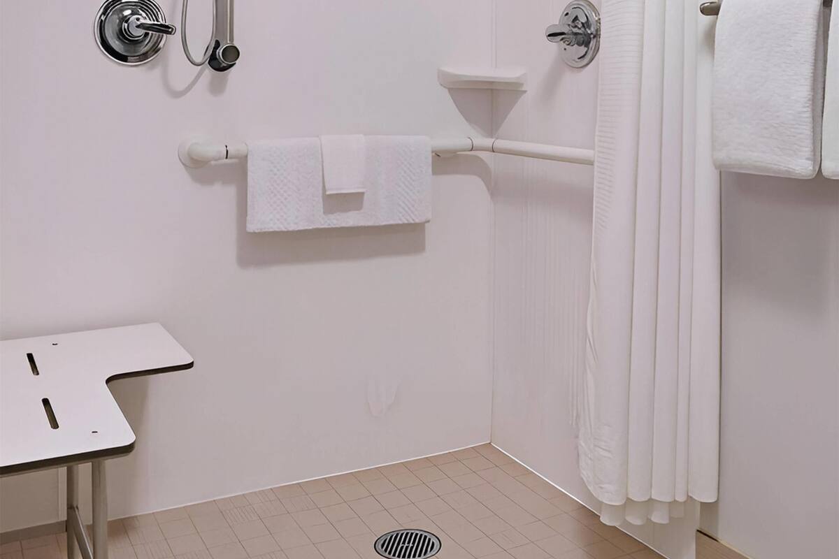 Un baño con ducha, lavabo, toallero y retrete.