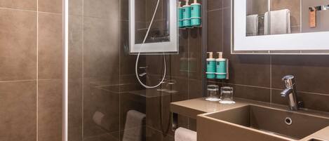 A modern bathroom with a shower, a sink, and a mirror.
