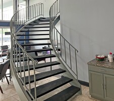 A spiral staircase with metal railings leading to a landing area.