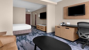 Une chambre d’hôtel comprenant un lit, un bureau, une chaise, une télévision et une armoire.