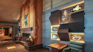 A modern lobby with a fireplace, seating area, and decorative wall art.