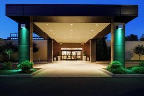 A modern building entrance with a covered walkway, large pillars, and a well-lit facade. - Holiday Inn Hotel & Suites Charleston West by IHG (South Charleston)