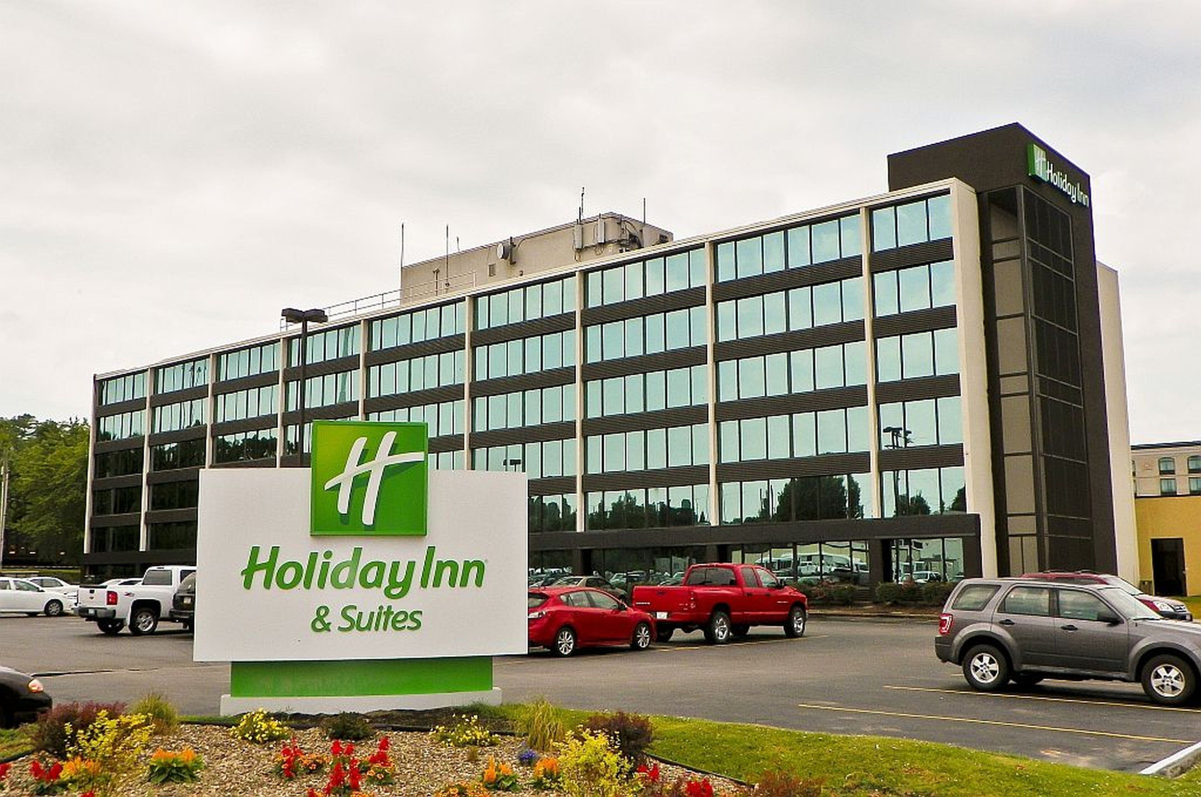 A Holiday Inn & Suites building with a large sign in front.
