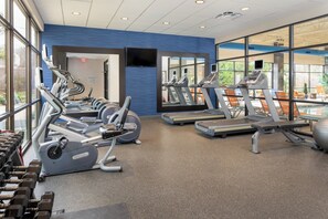 A gym with cardio equipment, weight machines, and a mirror wall. - Holiday Inn Hotel & Suites Charleston West by IHG (South Charleston)