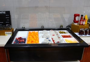 A breakfast buffet with various fruits, cheeses, and condiments. - Holiday Inn Hotel & Suites Charleston West by IHG (South Charleston)