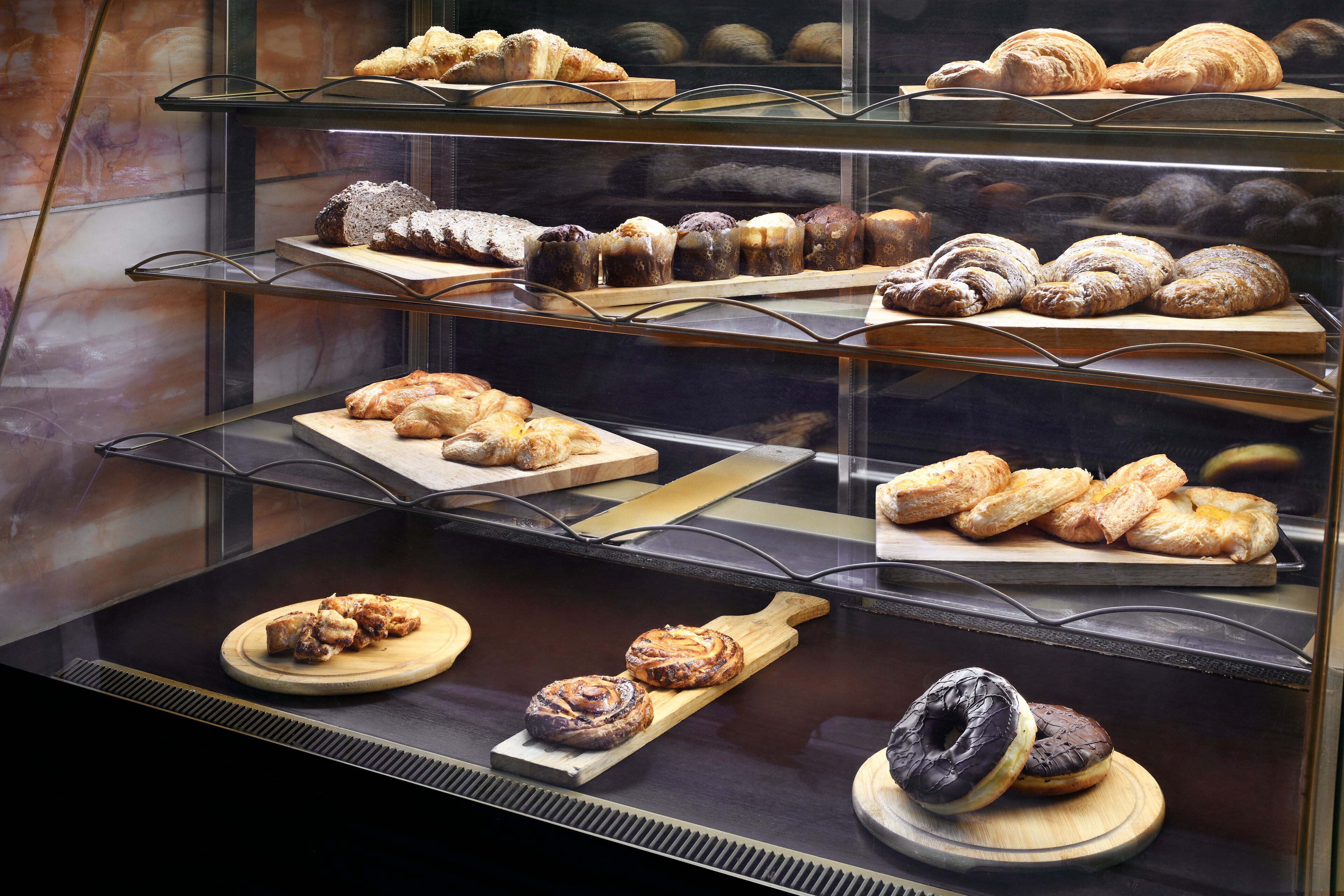 Un expositor de panadería con diversos productos de repostería.